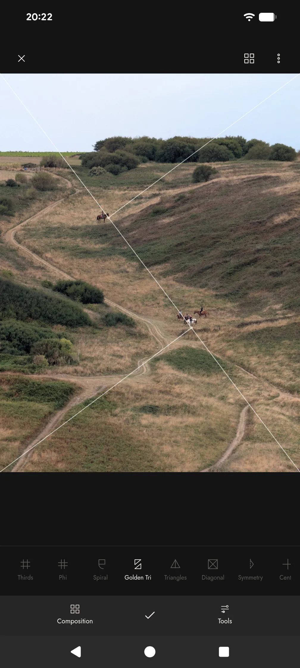 Golden triangle guide over a hillside with riders on a path