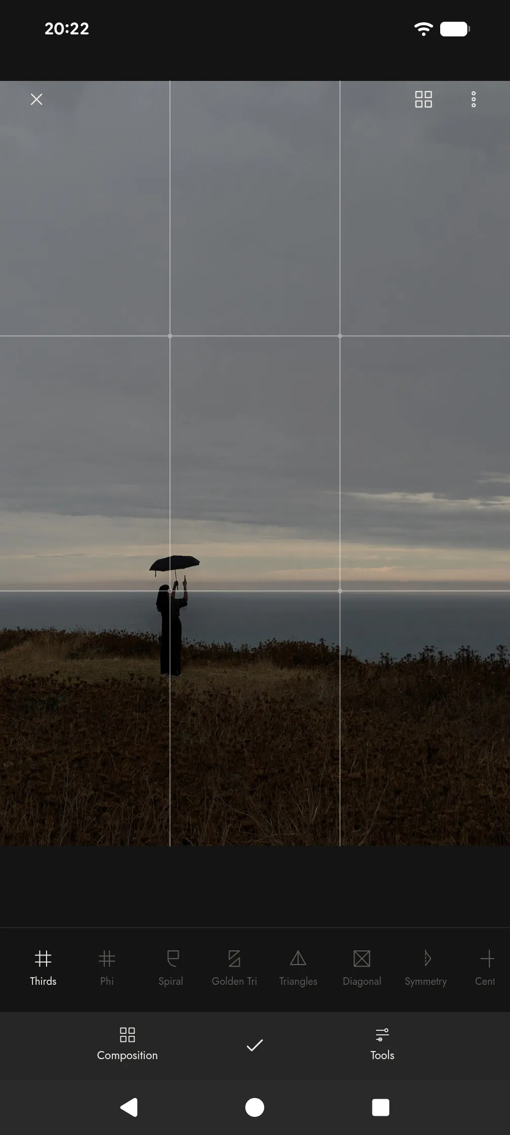 Keep Framing studio with rule-of-thirds guides over a photograph of a person under an umbrella on a cliff